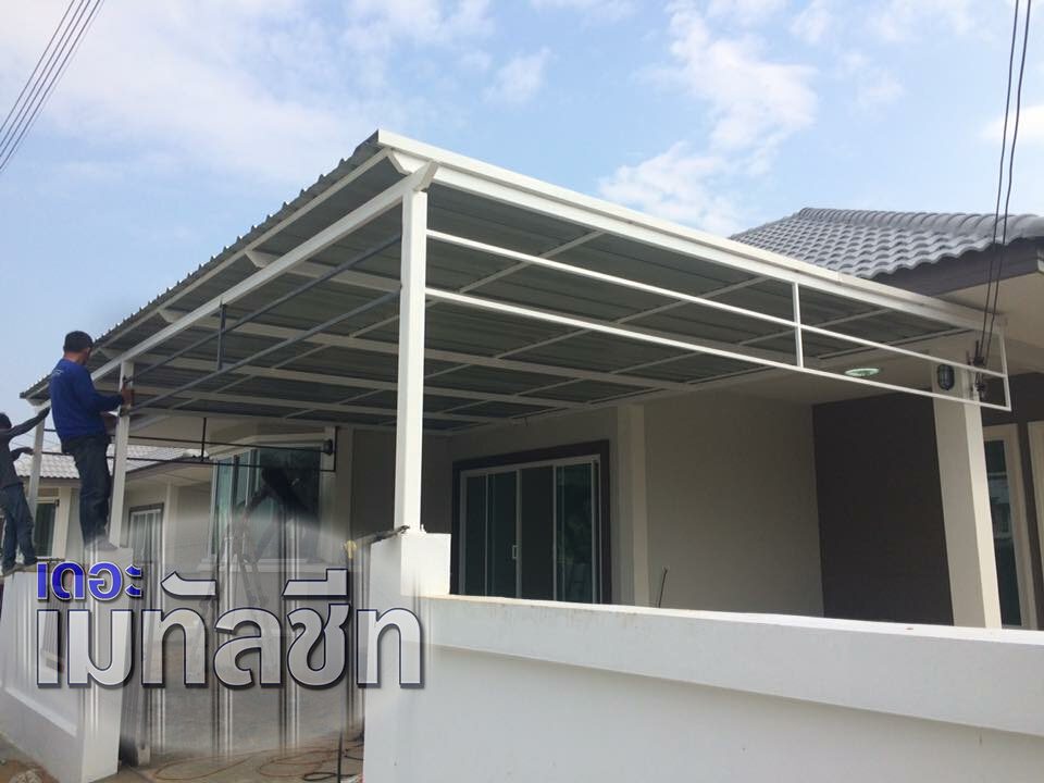 ทีมช่างกำลังติดตั้งกันสาดโครงเหล็กสีขาวหน้าบ้านโมเดิร์น